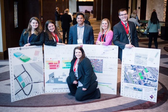 Students participants standing with their poster presentations.